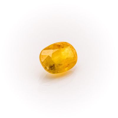 a yellow sapphire stone on a white background