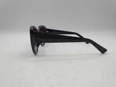 une paire de lunettes de soleil noires posée sur une surface blanche