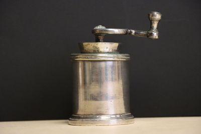 a silver coffee grinder sitting on a table