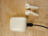 a pair of airpods plugged into a charger on a wooden table