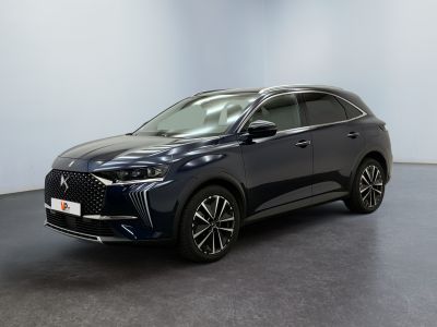 un SUV bleu foncé garé dans une pièce au sol noir