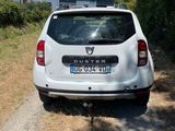 a small white car parked on the side of the road