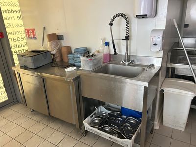 a kitchen with a sink, dishwasher, and other items in it