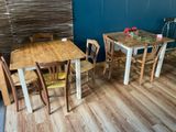 des tables et des chaises dans une pièce aux murs bleus et au parquet