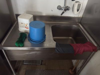 a sink with a blue bucket and a blue bucket on it