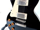 a black electric guitar sitting on top of a stand