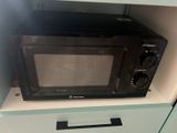 a microwave sitting on top of a cabinet in a kitchen