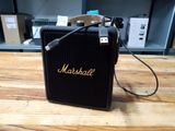 un amplificateur Marshall posé sur une table en bois