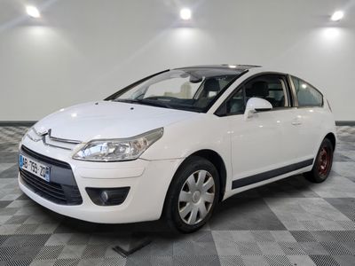 La voiture blanche est garée sur le sol à damier du garage.
