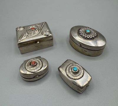 quatre bijoux en argent posés sur une table