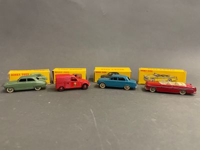 Quatre petites voitures sont alignées en rang sur une table