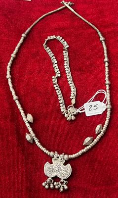 un collier et des boucles d'oreilles posés sur un tissu rouge, avec une étiquette de prix