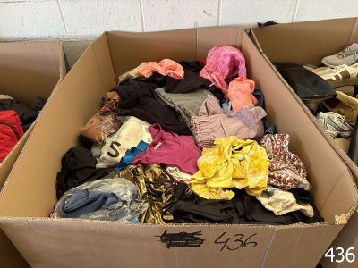 a cardboard box filled with clothes and other items