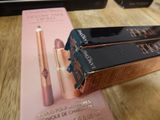 two boxes of lipstick sitting on a table next to each other