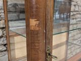 a close up of a wooden display case with glass doors