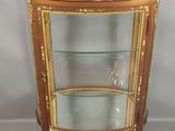 une vitrine ancienne avec des étagères en verre et des finitions dorées