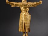 an image of a gold statue of a woman holding a shield