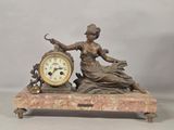 a statue of a woman holding a clock on top of a table