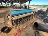 a large blue machine sitting on top of a dirt covered field