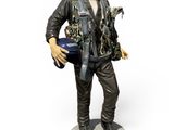 statue d'un homme armé d'un pistolet et portant un casque, posée sur une surface blanche