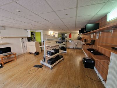 a room with a television, a desk, shelves, and a television
