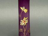 a purple vase with yellow and white flowers on it