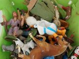 a green bowl filled with toy figurines on a white table