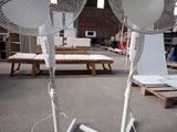 two white fans that are sitting in a room