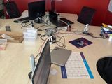Plusieurs ordinateurs portables sont posés sur une table dans un bureau.