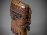 an old wooden head of a man with a mustache and a hat