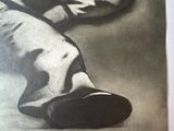 black and white photograph of a man ' s feet in a pair of shoes
