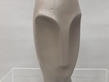 une sculpture représentant une tête, exposée dans une vitrine