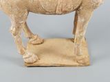 an old statue of a man riding a horse on top of a wooden base