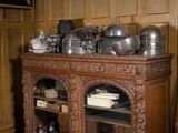 a wooden cabinet with pots and pans on top of it