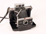 an old polar camera sitting on top of a black stand