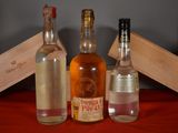 three bottles of alcohol sitting next to each other on a table