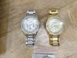 two watches sitting on a wooden table next to each other