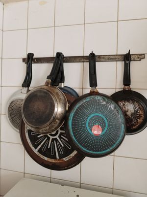 des casseroles et des poêles suspendues à un support dans une cuisine