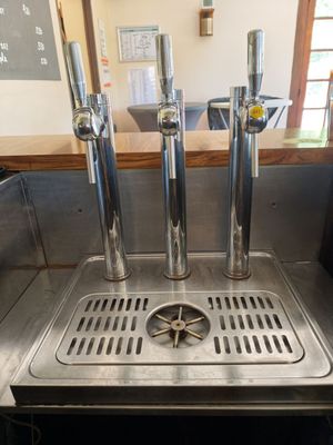 a metal sink with a bunch of beer taps on it