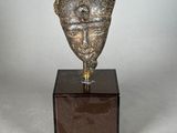 statue of a man ' s head on a wooden base