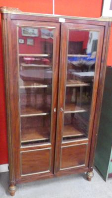 un grand meuble en bois avec des portes en verre dans une pièce