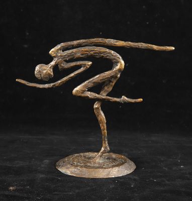 une sculpture en bronze représentant un homme sur un skateboard, sur fond noir