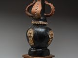 un vase noir orné d'un motif doré sur le dessus