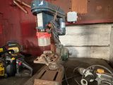 une perceuse posée sur un établi sur lequel se trouvent des outils
