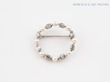 a close up of a ring with pearls on a white surface