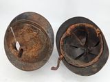 two old rusty pots sitting next to each other on a white surface