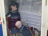 deux poupées dans une vitrine avec des partitions