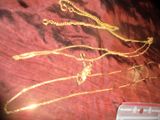 une photo d'un collier en or posé sur un tissu rouge