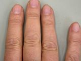 a person ' s hand with a ring on it ' s finger