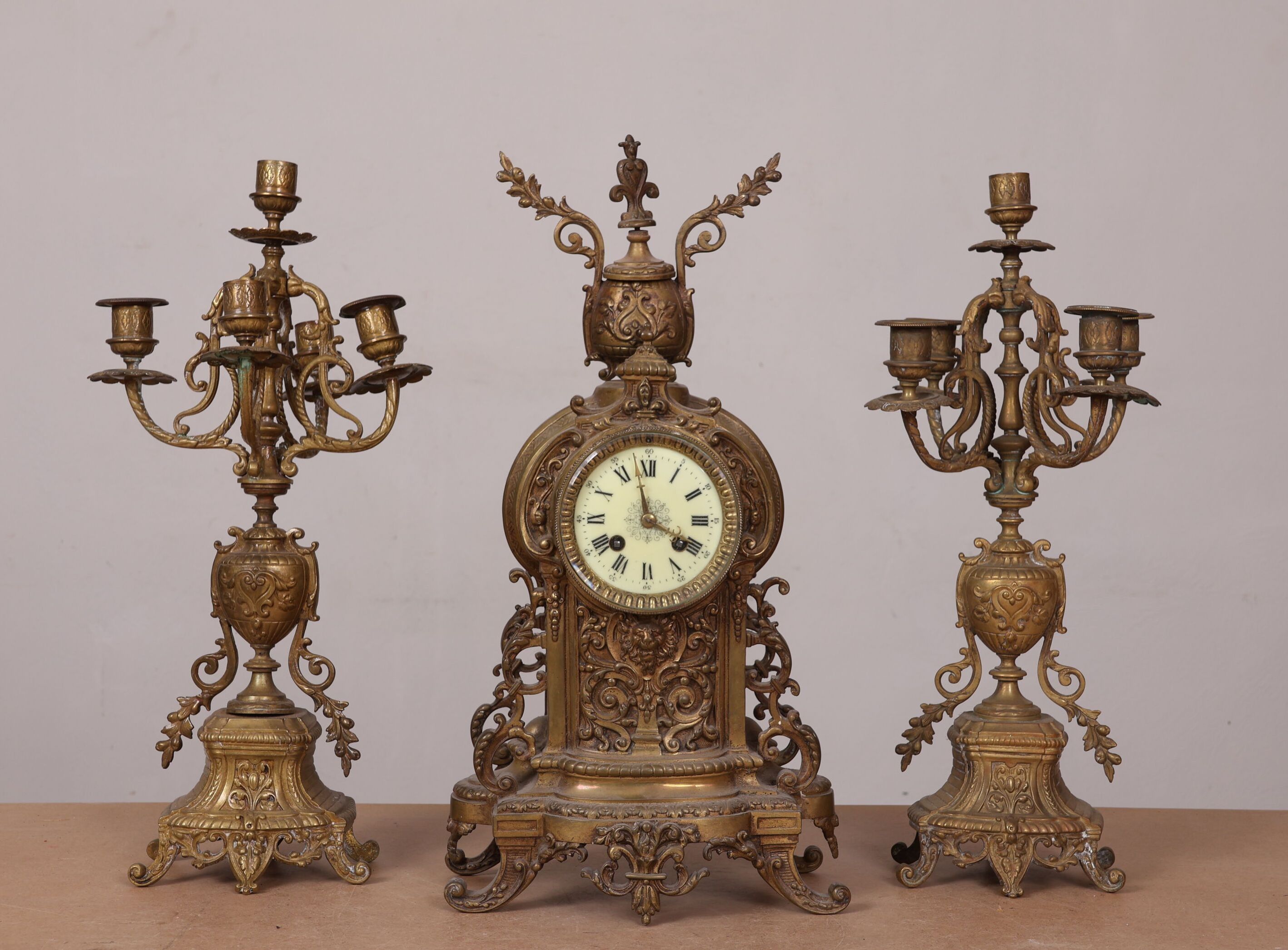 Garniture de cheminée en bronze ciselé et doré à décor de rinceaux et mufles de lion. Elle comprend une pendule et un...